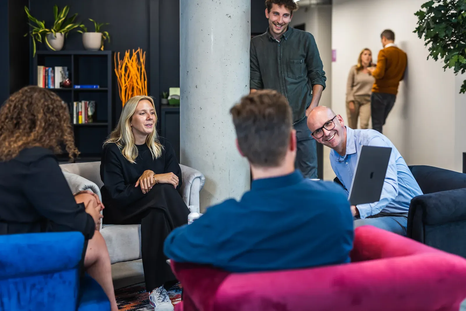 Harmony-collega's in gesprek in de zithoek van het kantoor