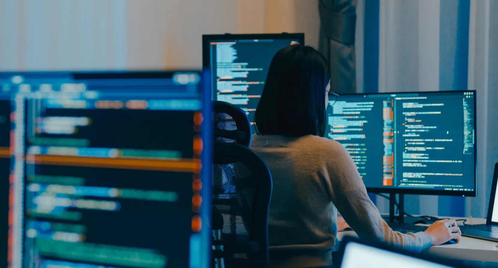 Een ontwikkelaar werkt aan code op meerdere schermen.