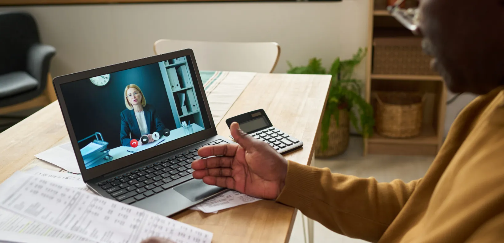 Een klant in een videogesprek met een adviseur op een laptop.